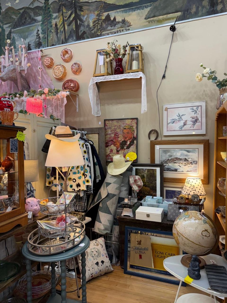 Vintage booth with a mountain mural, copper molds, hats and a lamp