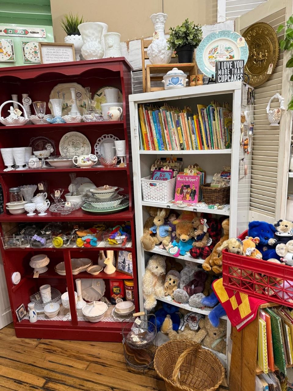 Milk glass displayed in a burgundy antique hutch