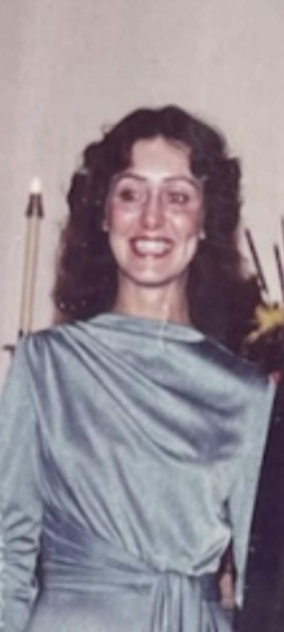 A young Lorraine, smiling in a vintage draped gown